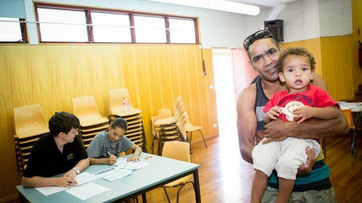 Citizen's right: Stephen Edwards with his son, Coen, while partner Melinda Jarrett fills out the forms for Coen's first birth certificate.  Photo: Supplied