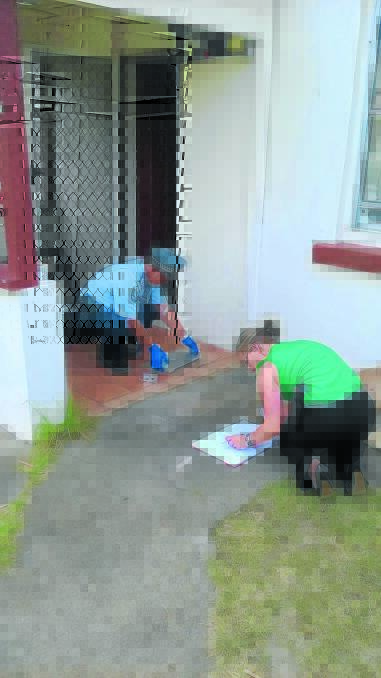 RAFT OF BREAK-INS: New England Police examine goods seized at the Butler St home during yesterday's raid. Photo: NSW Police