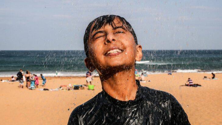 10 year old, Ansh Sambyal from Schofields washes the salt and sand off after escaping the heat at Bilgola Beach in Sydney's northern beaches on Saturday, September 23, 2017. Photo by Cole Bennetts