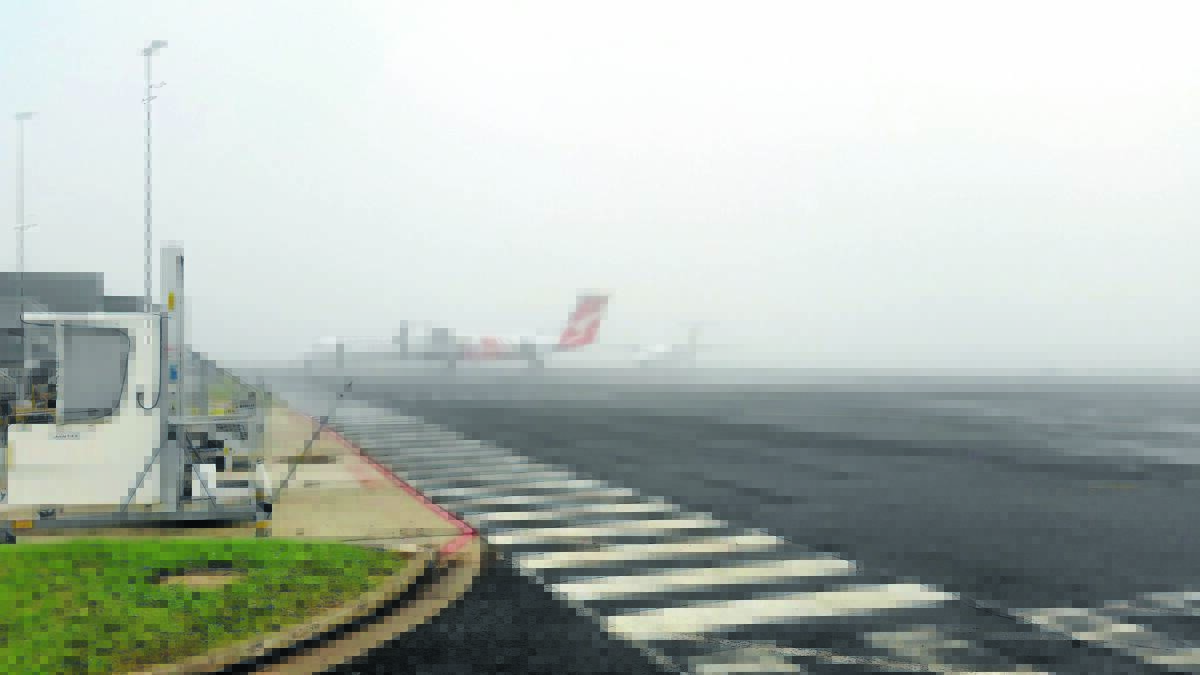 MURKY SKIES: Two QantasLink aircraft sit and wait for the fog to clear from Tamworth Regional Airport yesterday. Photo: Len Klumpp