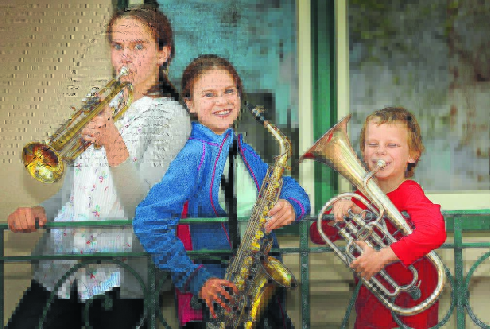 RIGHT  TUNING IN: Sibling buskers Leah Griffiths, 14, Hannah Griffiths, 11, and Caleb Griffiths, 8, spent their school holidays playing in Peel St. Photo: Geoff O Neill 260914GOD01