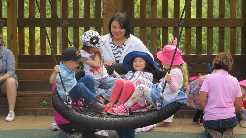 Myuki with Mia and other children enjoying the giant swing at the playground