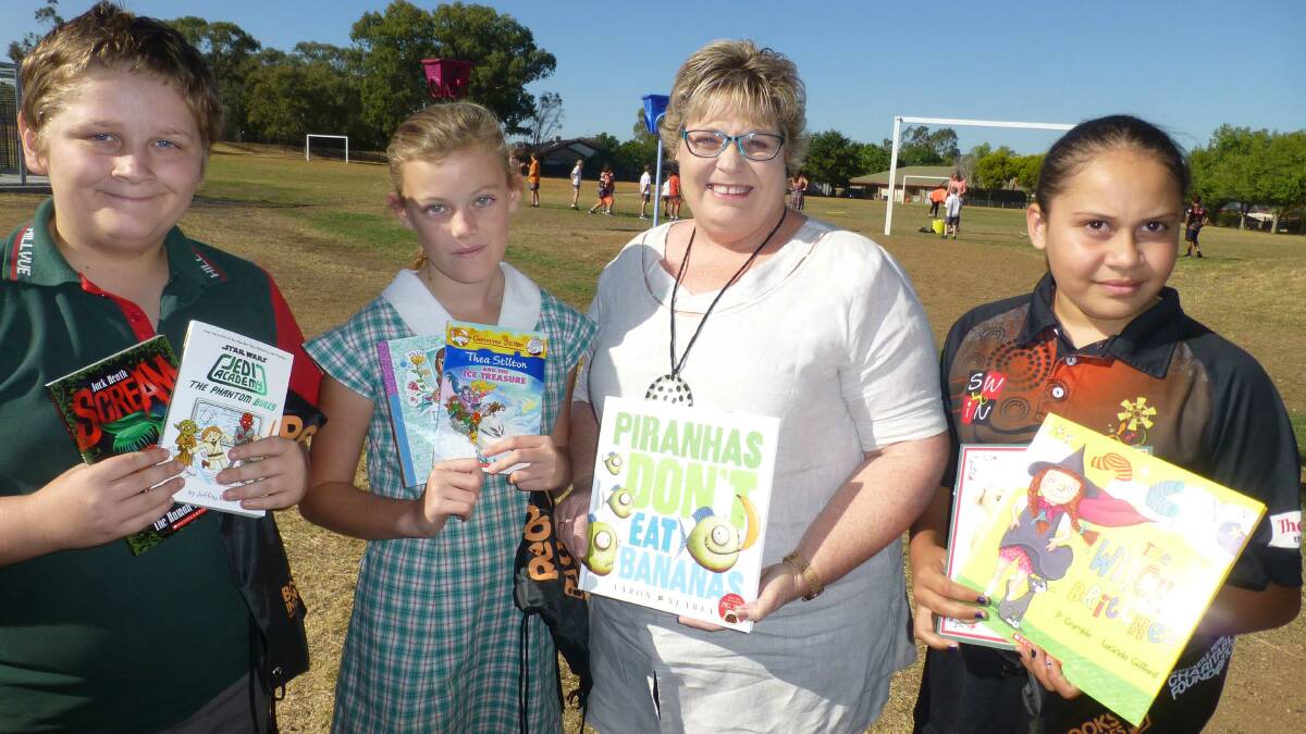Cameron Lee, Eleisha McKay, author Lyn Grace and Savannah Nean with some of the books Hillvue students can now take home