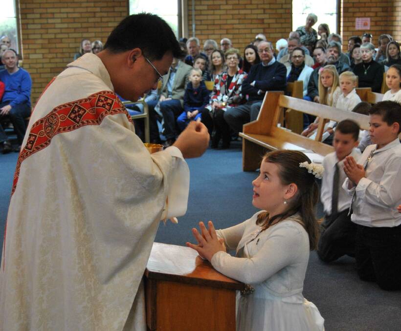 Hannah Evans receives her First Eucharist at Mary Help of Christian's church