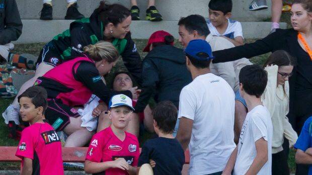 Unlucky: The young spectator is treated after being hit by a deflected six. Photo: AAP
