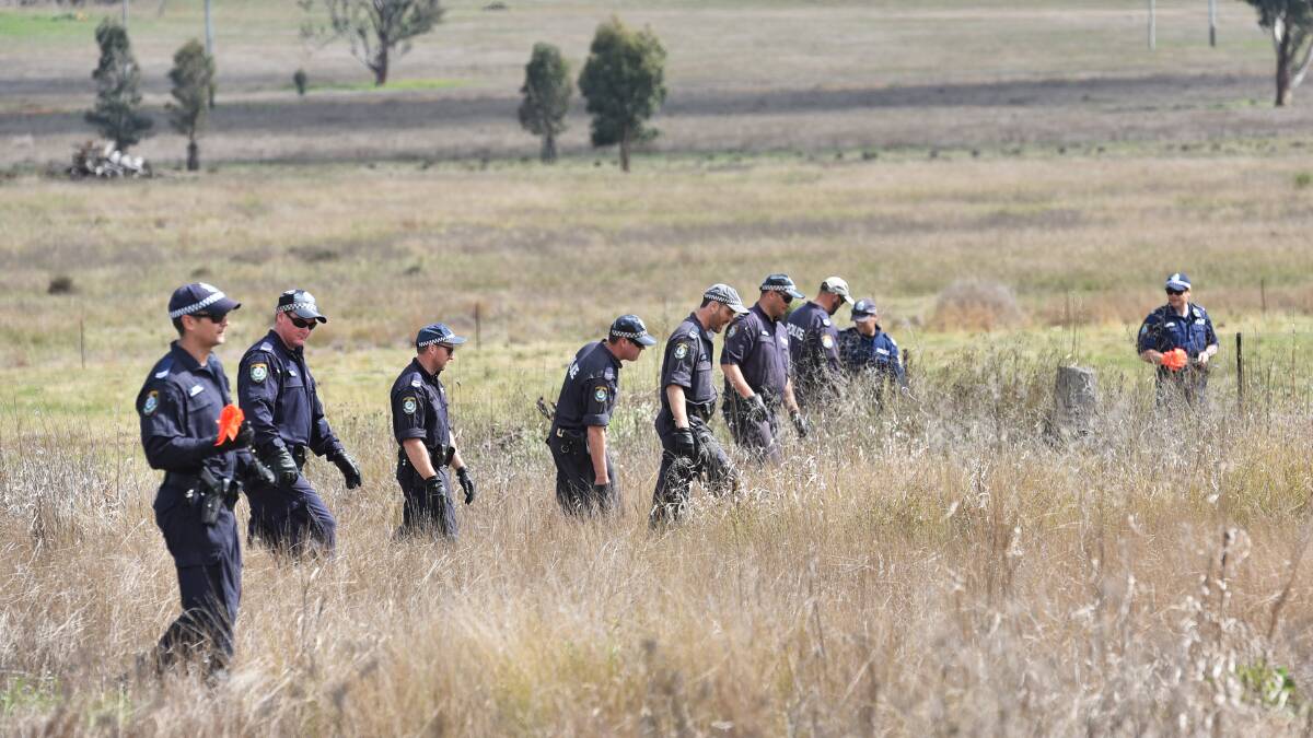 ON THE GROUND: Trained Oxley OSG police conduct a line search of a vacant paddock at the back of Coledale in August, near where missing mother Johann Morgan was last seen at her Cole Rd home. Photo: Geoff O'Neill 250815GOA04