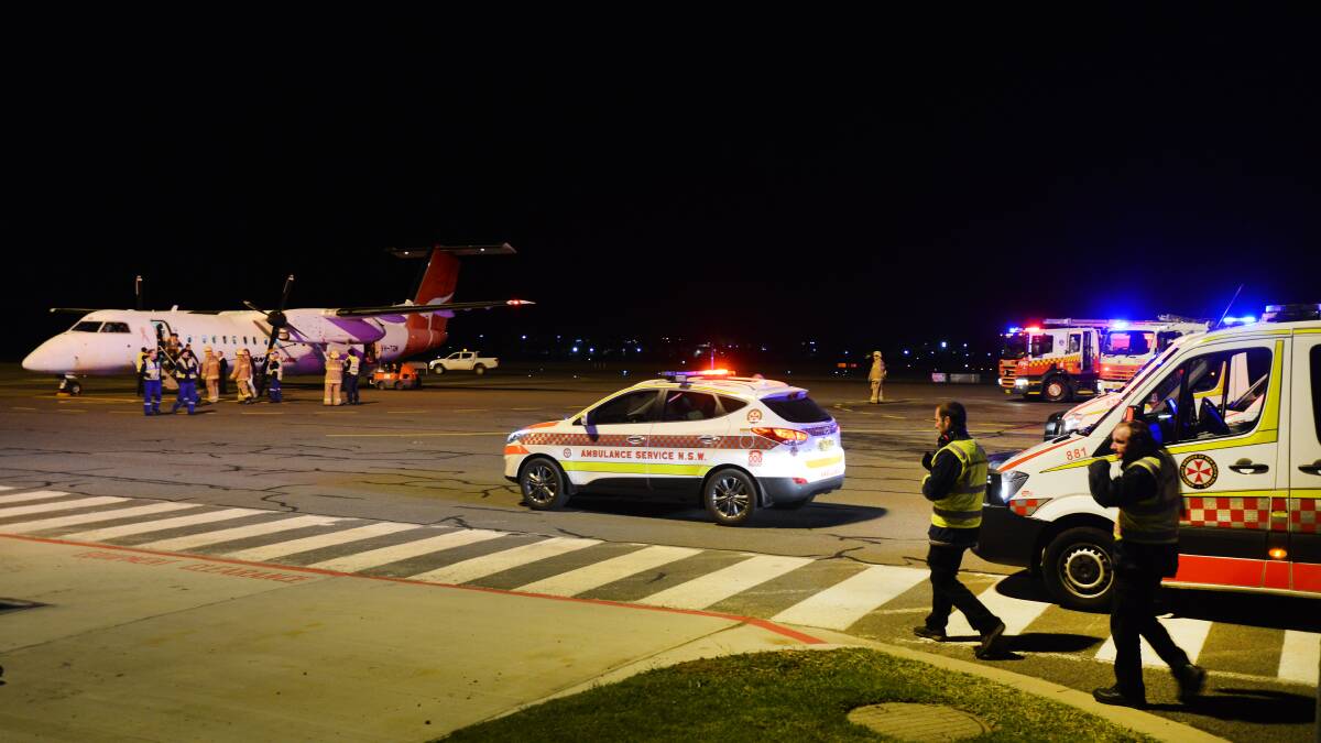 smooth LANDING: Emergency services assembled on the runway at Tamworth Airport on Tuesday night after a tyre blew on a Qantaslink flight bound for Armidale. Photo: Gareth Gardner 170614GGC05