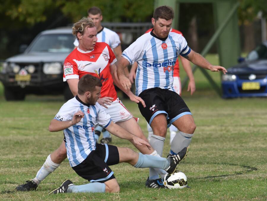OVA’s Matt Alcorn is wedged by the attention of Tamworth FC’s Jack Byrne (ground) and Tim Smith. Photo: Geoff O’Neill 020515GOF02