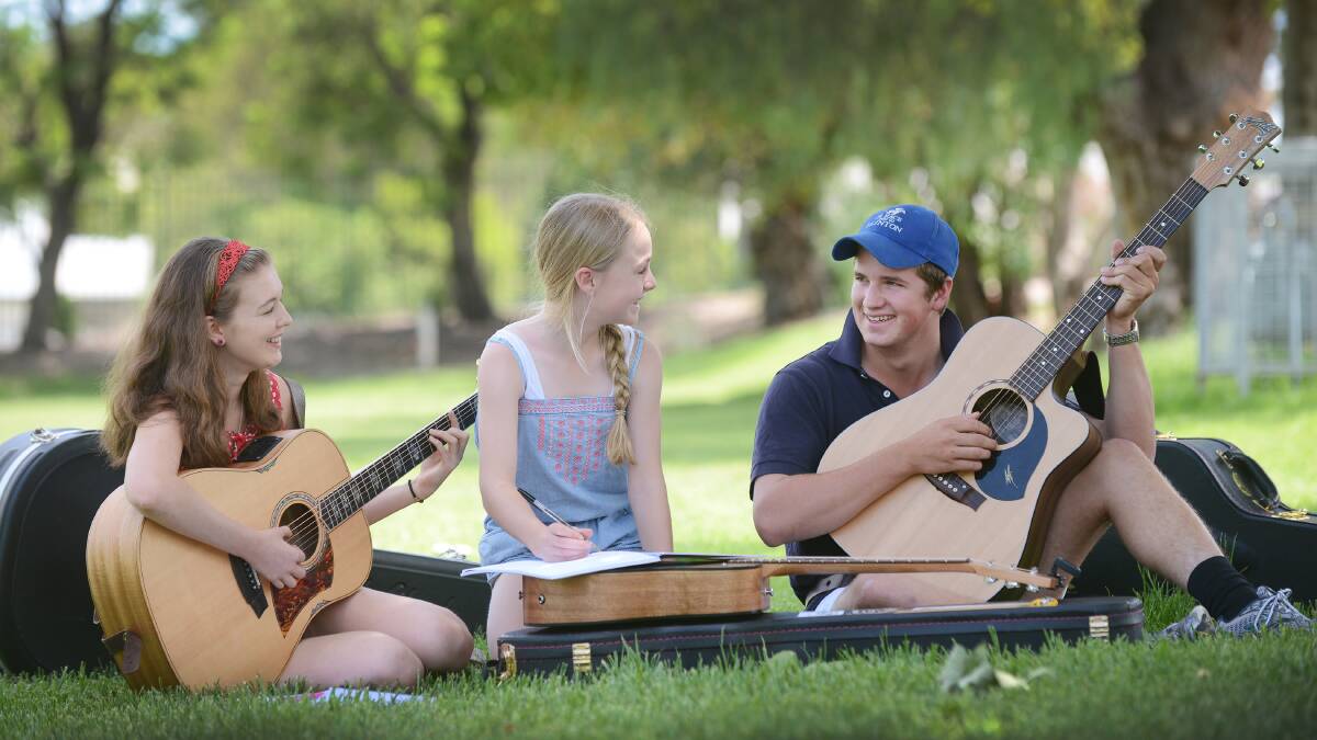 SONGWRITING SESSIONS: CMAA Country Music Academy junior students 14-year-old Ruby Gilbert from Moorina Queensland, 11-year-old Ella Radbone from Adelaide and 17-year-old Tim Drury from Miles in western Queensland taking time to write. Photo: Barry Smith 100115BSB02