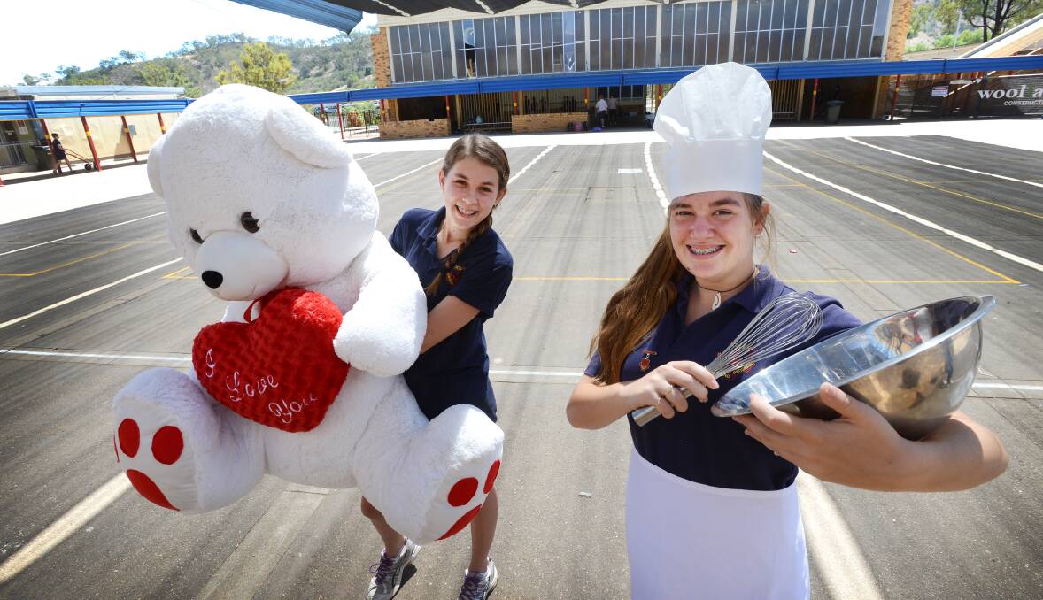 FOODIE TRAVELS: Year 8 students Libby Wise with the bear prize, and Isobelle Daley as the chef, are ready to celebrate International Night at Oxley High. Photo: Barry Smith 130314BSB02