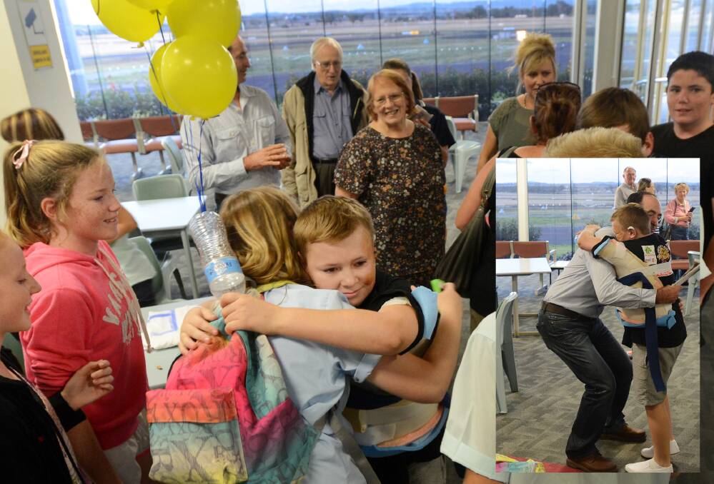 HOMECOMING: Josh McCulloch was greeted by a welcoming party at Tamworth airport on Monday night after receiving treatment for his severe burns. Photo: Gareth Gardner 2403314GGF04 INSERT _ DON’T LET GO: Josh McCulloch embraces his dad, Paul, at Tamworth airport on Monday. Photo: Gareth Gardner 240314GGF02