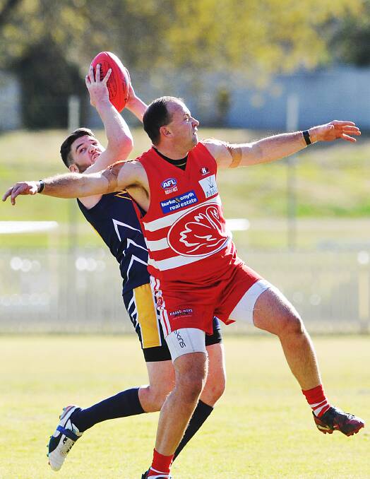 Tamworth Swans stalwart Gavin Knee (front), who kicked three goals in Saturday’s win over Narrabri, cannot stop this Eagle mark in a rare win for the visitors at No 1 Oval, Tamworth.  Photo: Geoff O’Neill 120714GOF04
