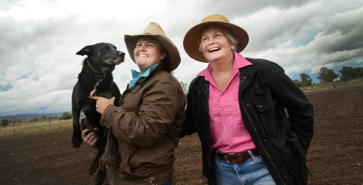 THE OATS ARE IN: Emma, left, and Janet Redden look as pleased as their dog Wombi with the steady, soaking rain received yesterday. Photo: Gareth Gardner 240314GGC02