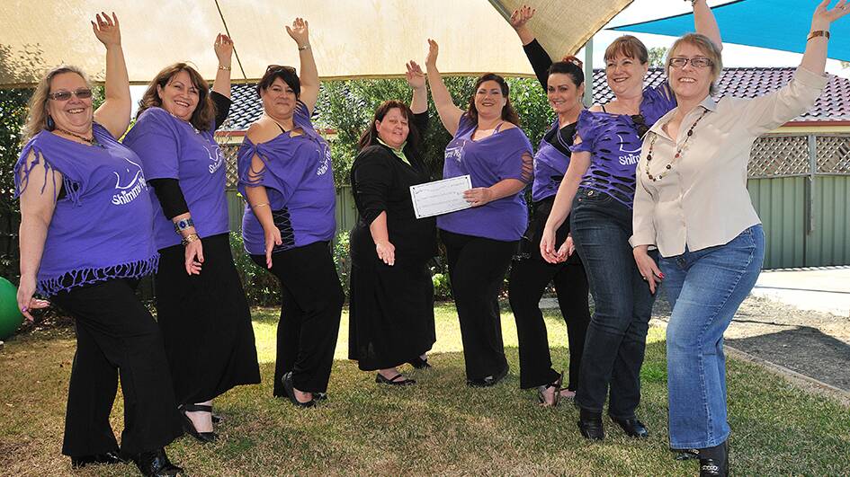 LET’S SHIMMY: Local belly dancers presented a $6510 cheque to the Tamworth Women’s and Children’s Refuge last week . From left are, Corry Taylor, Cheryl Gardiner, Mel Taylor, Charmane Holm, Rita Fisher, Tina Marshall, Carolyn Fieldus and Dea Mackintosh. Photo: Geoff O’Neill 290814GOF01