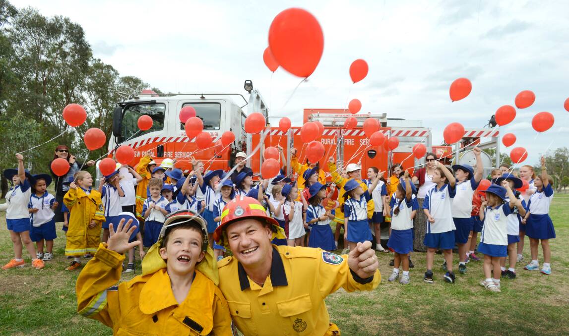THANKS, FIRIES: Year 2 student Tye Pittman with Allen Madden from the Kootingal-Moonbi RFS with the students and their red balloons thanking firefighters for their efforts during a difficult fire season. 
Photo: Barry Smith 280214BSA08