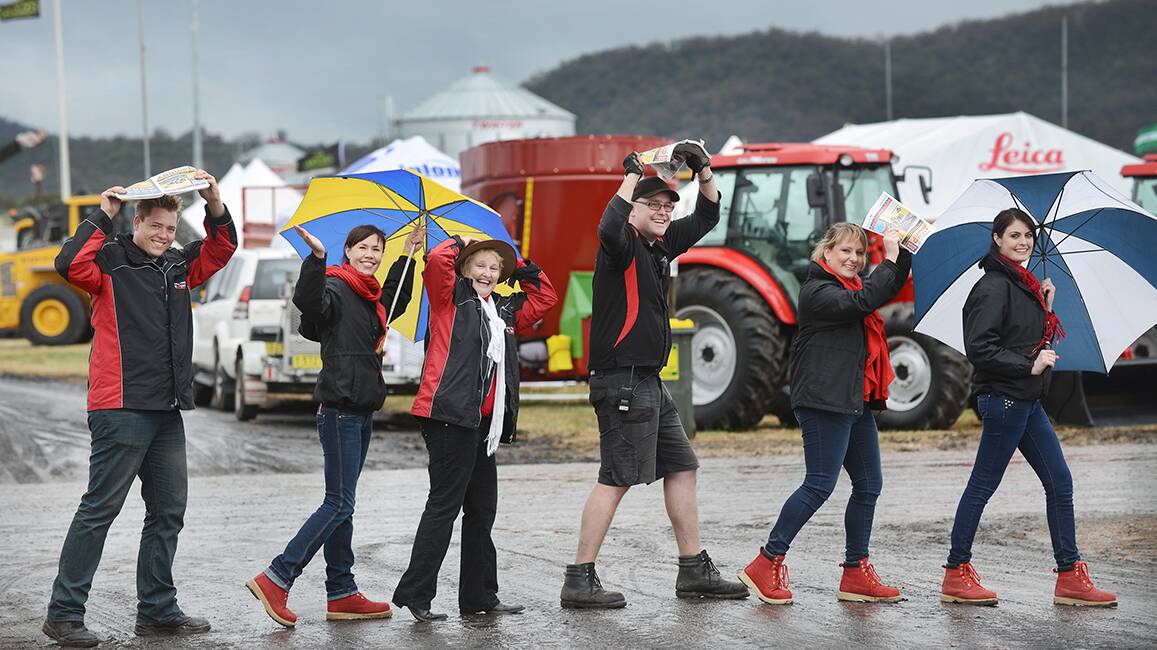 MUDDY ROAD: Bootscooting it across an AgQuip laneway yesterday but smiling in the slush were organising staffers, from left, Brett Clarke, Kristy Williams, Kate Nugent, Aaron Harley, Emma O’Connell and Luci Smith.  The agricutlural showcase gets underway today. Photo: Barry Smith 180814BSC06