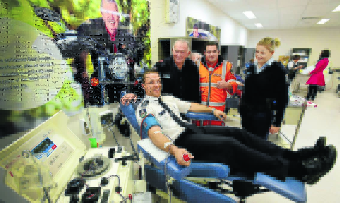 TO THE RESCUE: NSW RFS Inspector Sean Barton donating blood, with Fire and Rescue NSW firefighter Dennis Gross, SES volunteer Shannon Chambers and senior police officer Cindy Moore cheering him on as a lifesaver. Photo: Gareth Gardner 030715GGA01