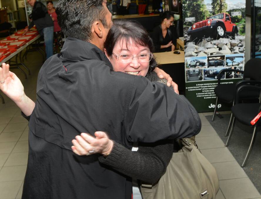 CASH CAVALCADE: South Tamworth mum Alison Kilroy hugs Woodley’s 
salesman Bryden Chand after winning $5000 in a unique competition on 
Monday night. Photo: Gareth Gardner 020614GGC02