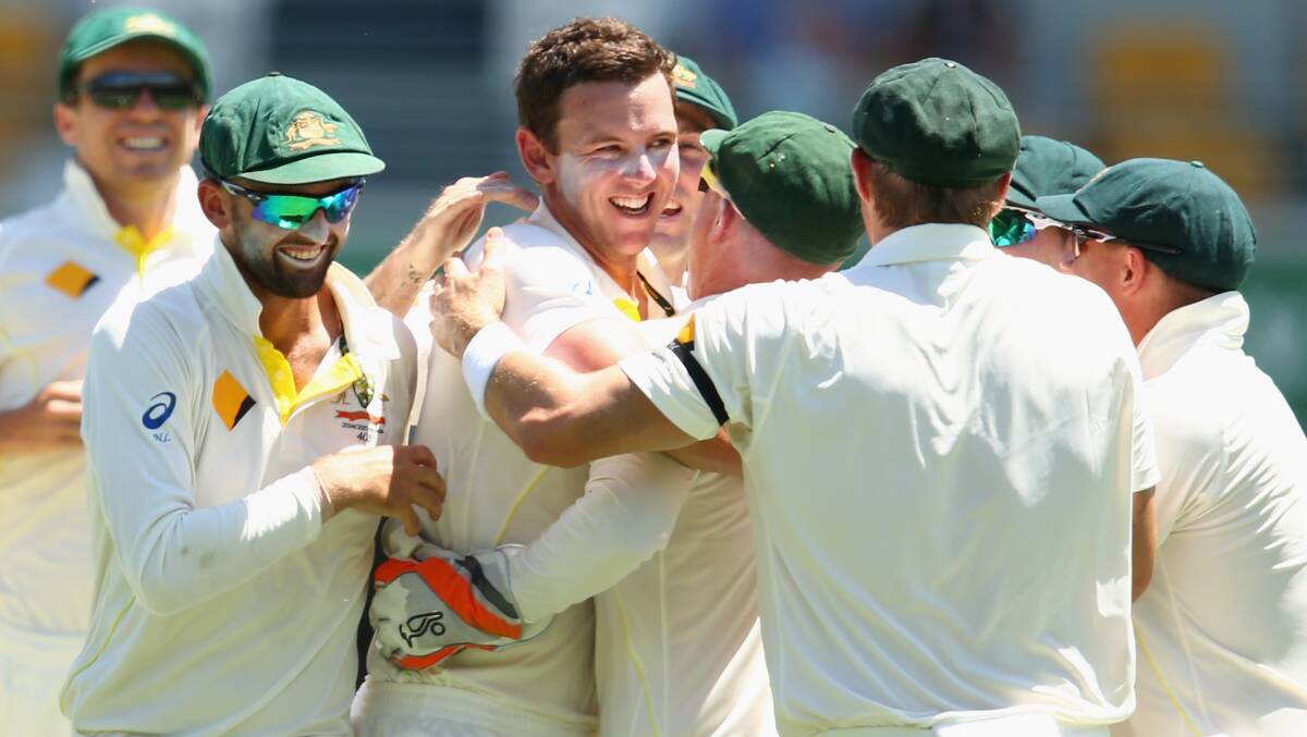 Bendemeer’s Josh Hazlewood celebrates his first Test wicket with his team mates in Brisbane yesterday.  Photo: Getty Images