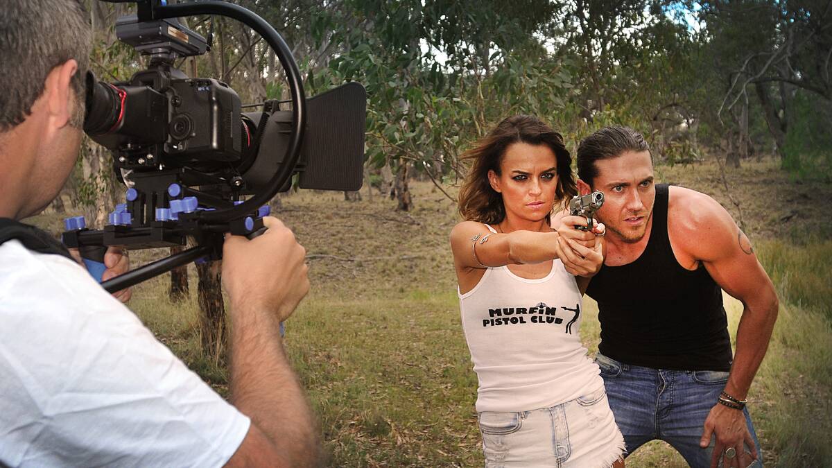 ACTION! Luke Oldknow shooting actors Bianca Bradey, the alpha female, and Jonathan Lane on the set of Zombie Dinosaur in Tamworth. Photo: Geoff O’Neill 071214GOE01
