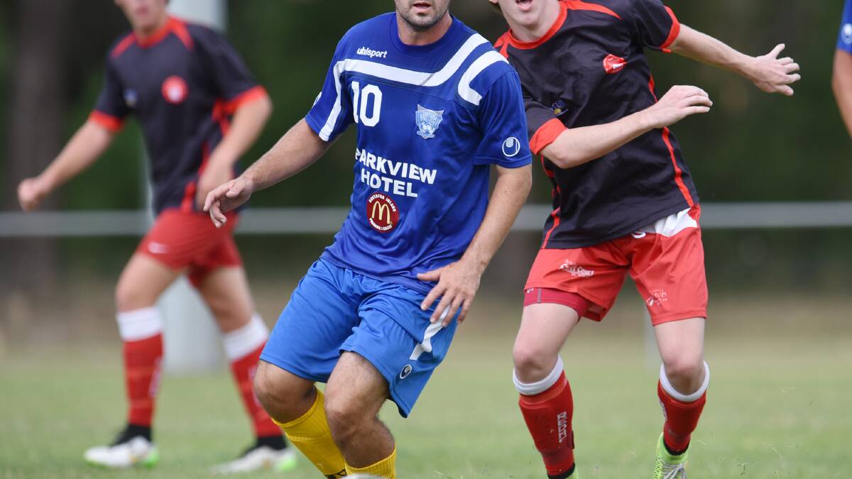 Gunnedah United’s Michael Cooke scored one of his side’s two goals in Sunday’s 3-2 FFA Cup loss to North Armidale. Redman. Brendan Pincham is reacting to Cooke’s play. Photo: Barry Smith 220315BSC21