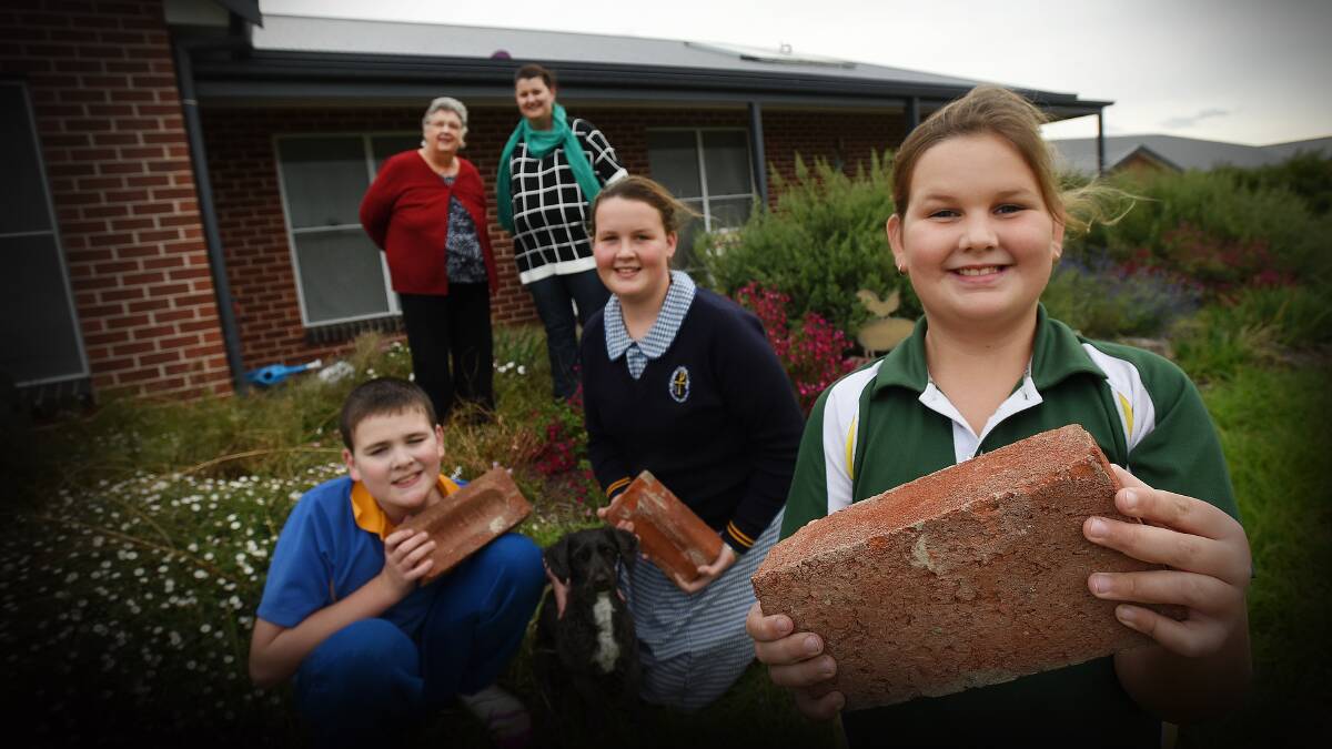 IN LOVING MEMORY: Nine-year-old Annie Kelly, front, with siblings Charlie, 11, and Abby, 13, will build a garden using old Nioka bricks in memory of their grandfather. Grandmother Christine Serry and mother Michelle Kelly look on. Photo: Gareth Gardner 010515GGD01