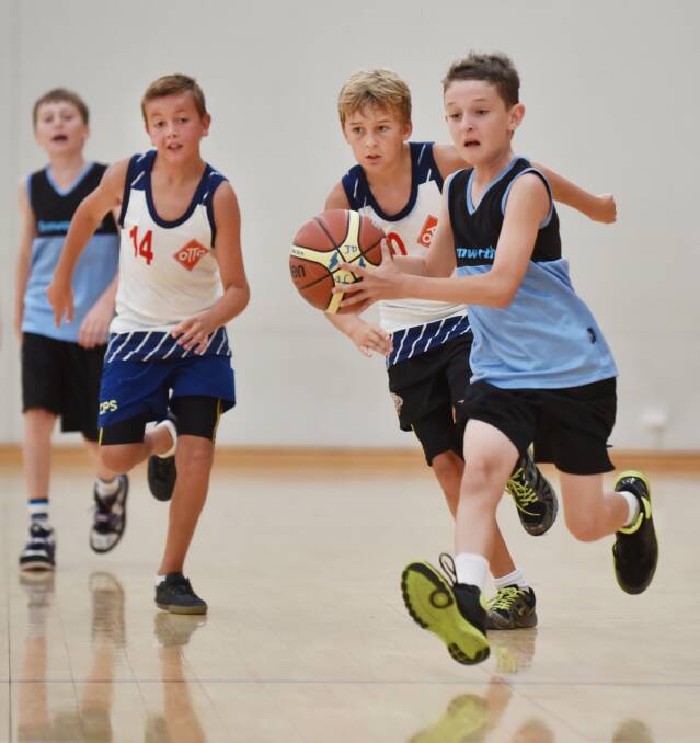 Tamworth’s Blair Kedlize drives down the court as John Martin (14) and another 
Coonabarabran-Coolah player give chase during yesterday’s North West primary boys’ trials.  Photo: Barry Smith 260215BSB14