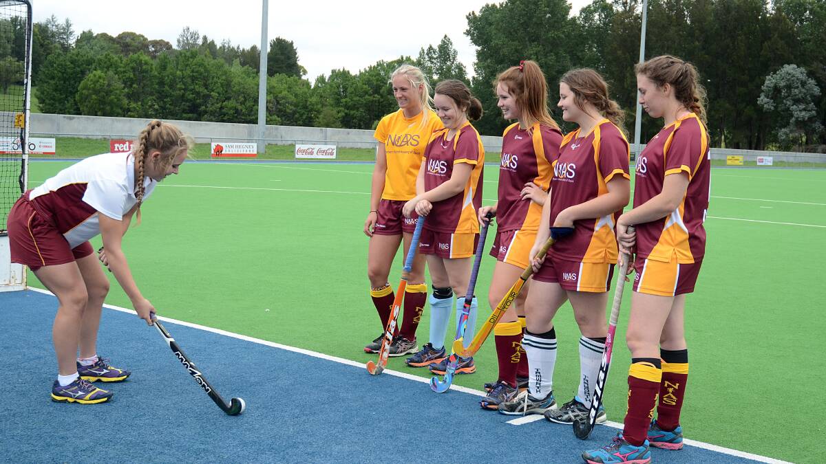Trainee coach Katrina Rekunow demonstrates a technique to NIAS Hockey Squad members Claudia Neilson, Libby Maher, Tess Pennefather, Gabby D’Ambrose and Maddie Powell, all of Tamworth. Photo: Pixonline