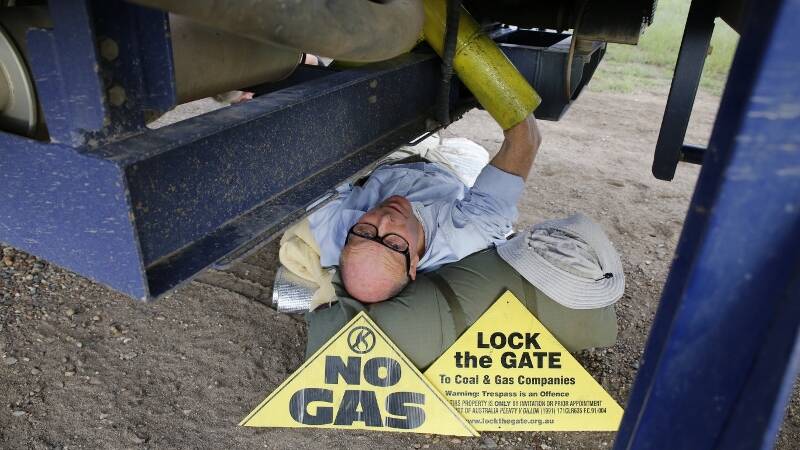 DESPERATE MEASURES: Simon Pockley, a 64-year-old business analyst from Coonabarabran, struggles to get comfortable while locked under a truck carrying coal seam gas drilling equipment on Saturday.