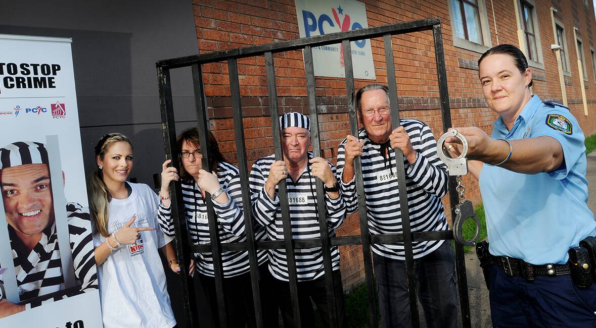 CRIMS IN TRAINING: From left, prisoners-to-be Jacqui Smith (Kensell Holden), Kathy Webb (The Good Guys), Col Gutteridge (Cheapa Music) and Mervyn Godley (Centrepoint) get used to being behind bars as Senior Constable Andrena Sandison warms up her handcuffs. 030414GGB01
