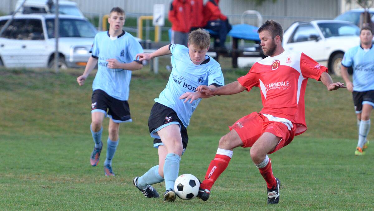 Tamworth FC’s Hayden Davidson (left) and North Armidale star midfielder Jason Boundy vie for possession in Saturday’s 3-1 win for the Redmen.
