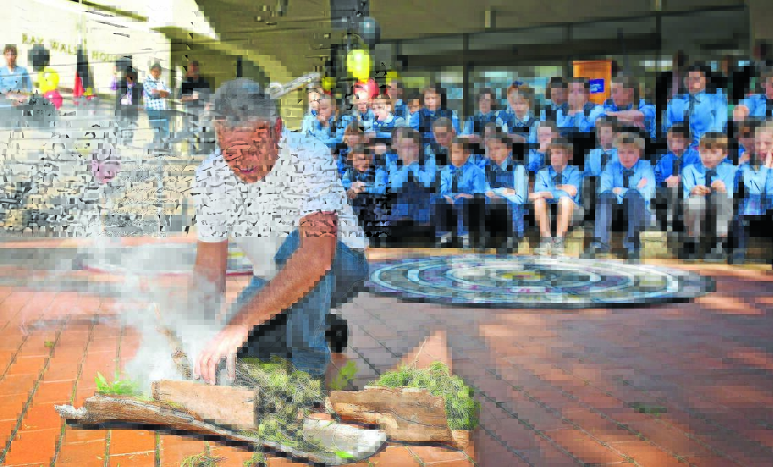 LOTS OF SIGNIFICANCE: Local Aboriginal elder Len Waters takes part in the smoking ceremony yesterday at the front of Ray Walsh House for National Reconciliation Week. Photo: Geoff O’'Neill 270515GOC01