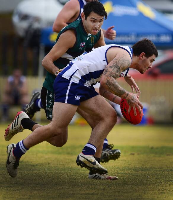 Brandon McRedmond made a good debut for the Roos on Saturday. Here McRedmond looks for a goalscoring advantage as former Broken Hill player Wulu Hall closes in for the Nomad tackle. Photo: Gareth Gardner  130615GGD06