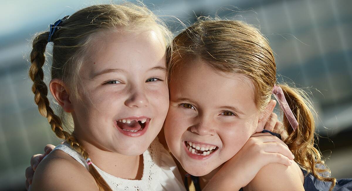OPEN WIDE: Tamworth’s Chloe Morris, 6, and Ella Jones, 5, show off their gap-toothed grins. Photo: Barry Smith 271114BSE05