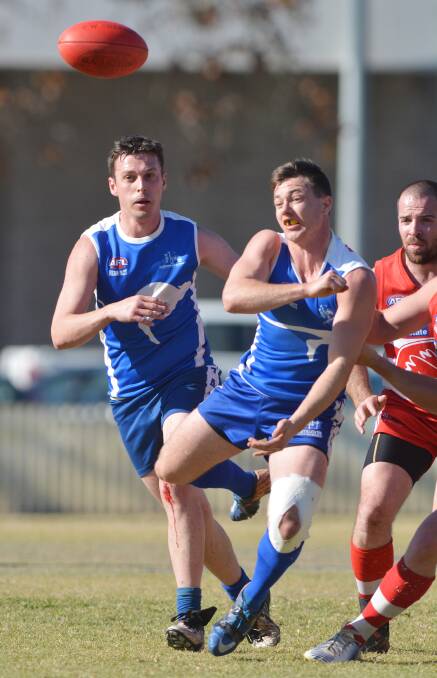 Tamworth Kangaroos’ Brock Quinn punches this ball clear during Saturday’s derby  as team-mate Chris Rankmore and Swans’ Shane Kilby look on.  
Photo: Barry Smith 090814BSD21
