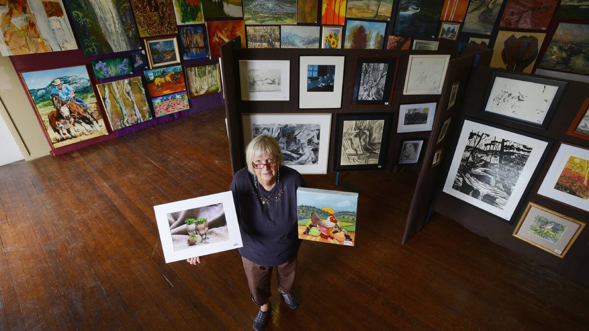 EXHIBITION GAINING PROFILE: Margaret Hemmings, one of the organisers of the Bendemeer Art & Craft Exhibition (The Colours of Autumn), with some artworks that represent  the Taste Tamworth 
Festival. Photo: Barry Smith 020414BSB04