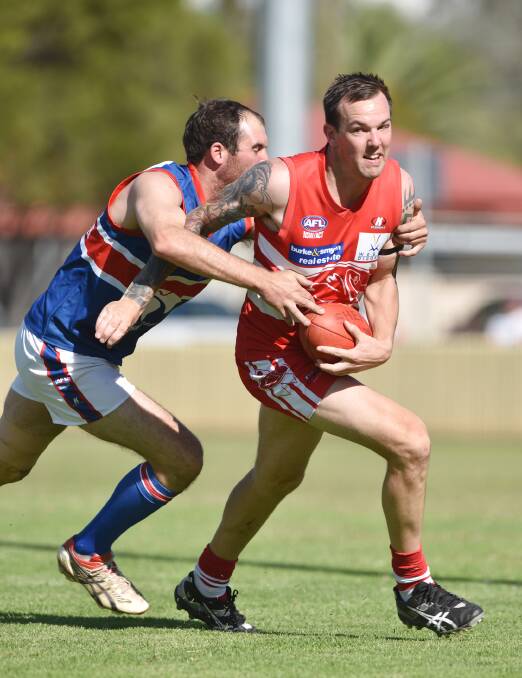 Tamworth Swan Adam Splithof tries to break the grasp of Gunnedah Bulldog Mitch Swain in a first-round TAFL match. The Swans host Moree Suns today while Swain and his  Bulldogs have to repel reigning premiers New England Nomads in Gunnedah. Photo: Barry Smith 110415BSC25