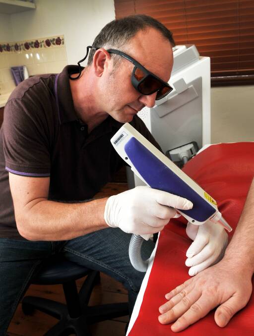 NOW YOU SEE IT ... Mark Woollven, of Laser Clear Tattoo Removal, is experiencing a boom in business. Photo: Gareth Gardner 020314GGB01