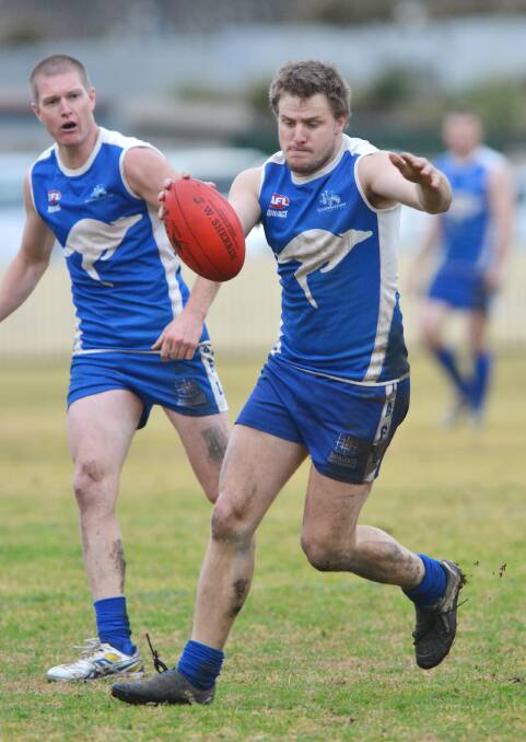 Roos assistant coach Matt Hodge won the Gillies Medal last season and kicks for goal here for the Roos. Luke Robinson (back) has been training the house down according to his coach and looks on. They will be key men against the Nomads in Armidale today.  Photo: Barry Smith  260714BSF11