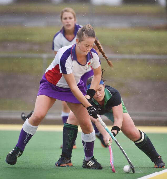 Services’ Kimmy Hill sneaks her stick in to try to dispossess Waratahs’ Katrina Rekunow. Photo: Barry Smith 310515BSD30