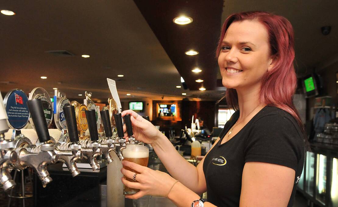 BRAND WARS: Longyard Hotel barmaid Holly Schultz pours a cold, frosty one at the pub on Friday. Publicans and club managers say traditional beer brands like VB and Carlton Draft are losing market share. Photo: Geoff O’Neill 230514GOE01