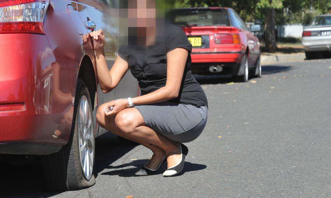SLASHING OFFENCE: Jess Coshal with a vehicle and its slashed tyres in Bent St.  Photo: Geoff O’Neill 280414GOB01