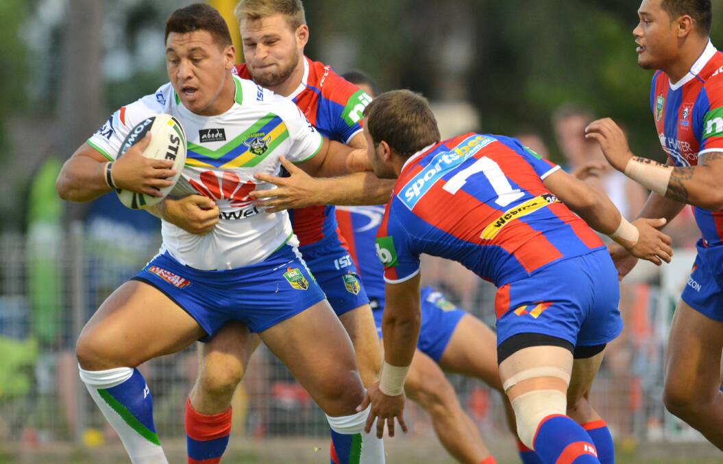 Canberra Raider Josh Papalii is surrounded by Knights defenders Robbie Rochow, Tyrone Roberts and BJ Leilua.   220214BSH02