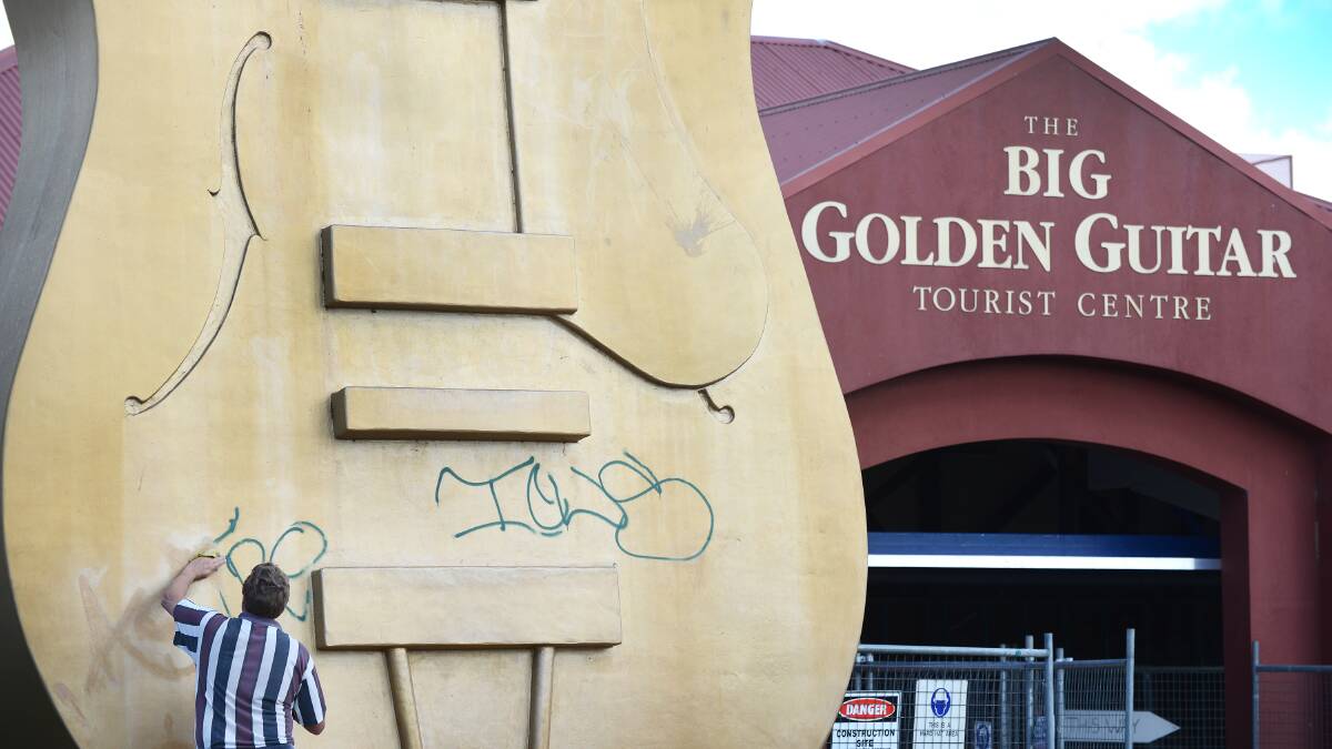 BUM NOTE: A worker attempts to remove graffiti from the Golden Guitar last week. The vandalism has prompted fresh calls for more security around the iconic structure. Photo: Barry Smith 260914BSA08