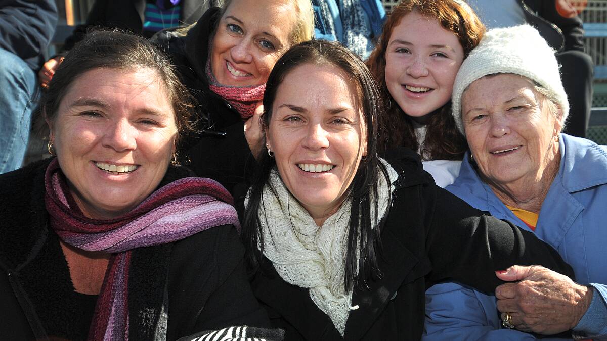 RUGGED UP: Gold Coast visitors, front from left, Anne McCartney, Marnie Sheldon and Marilyn Sheldon, with, back from left, Meaghan Mastroianni and Rhyannon Sheldon cheer on the teenage rugby league players at Scully Park. Photo: Geoff O’Neill 240614GOA03