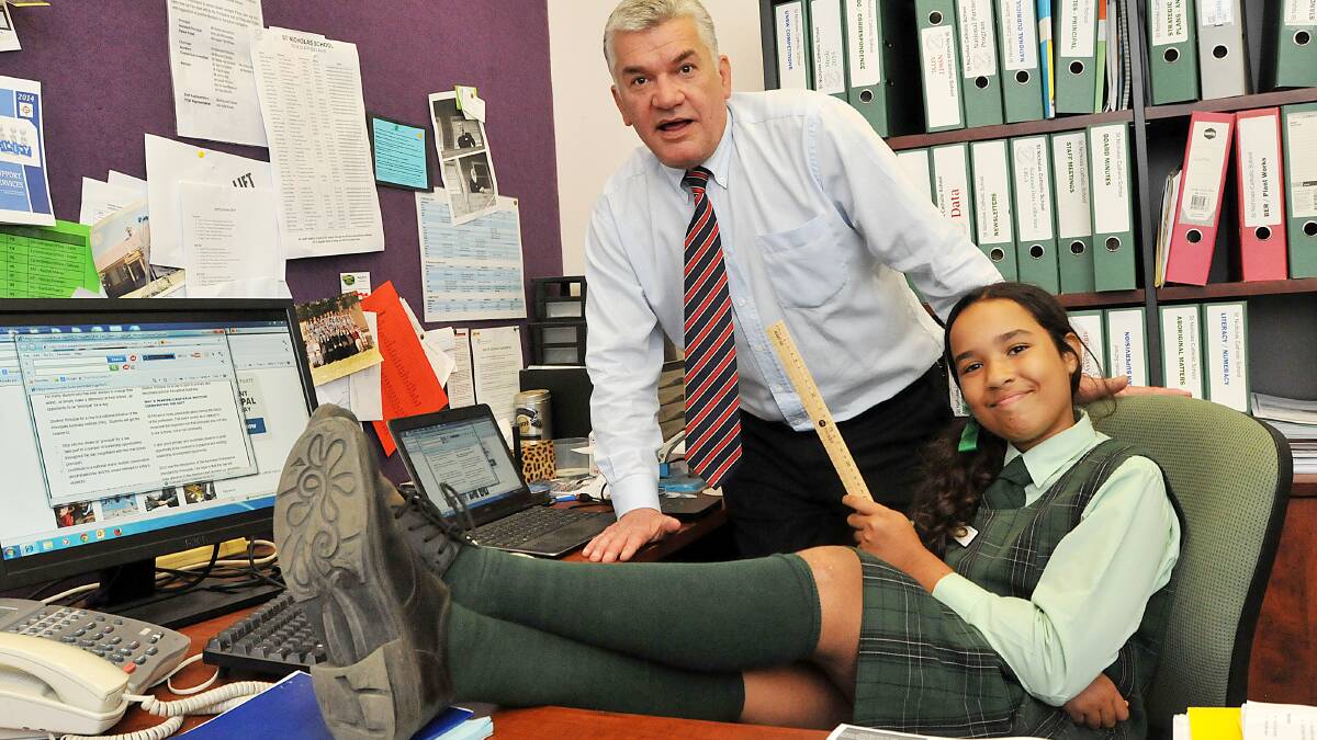 REVERSAL: 
St Nicholas Primary School Year 6 pupil Keeley Day tests out principal Stefan van Aanholt’s chair ahead of playing principal for a day next week. Photo: Geoff O’Neill 280514GOD02