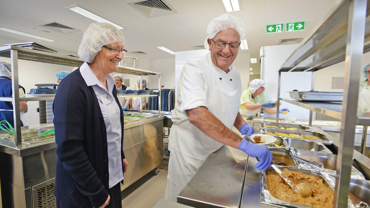 SERVING WITH A SMILE: Food service supervisor Carol Egan and Russell Williams serve lunch at Tamworth hospital’s new kitchen. Photo: Barry Smith 220914BSA03
