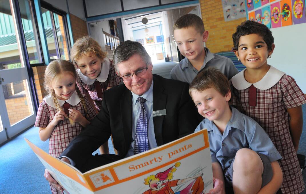 BOOKWORMS: Dr David Cullen takes time out to read a book with Oxley Vale Public School Year 1 students yesterday – from left, Lily Heap, Mia Robinson, Colby Jeffery, Olivia Holz and Troy Bennett. Photo: Gareth Gardner 090414GGC02