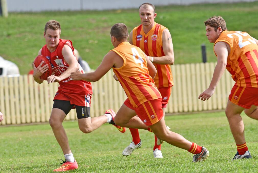 Tamworth Swan Brad Walters prepares to fend off the looming tackle of Moree Suns’ Liam Wright as Suns’ Duncan Macey (back) and Kevin Mills (right) consider their defensive roles. Photo: Geoff O’Neill 020515GOE03