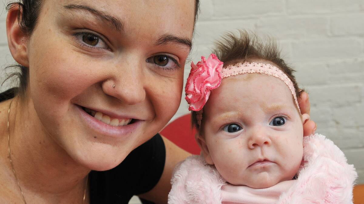 PRETTY IN PINK: Miracle baby Alexi Louise with her proud mum Rachael Dimmock.
Photo: Geoff O’Neill 010514GOF03